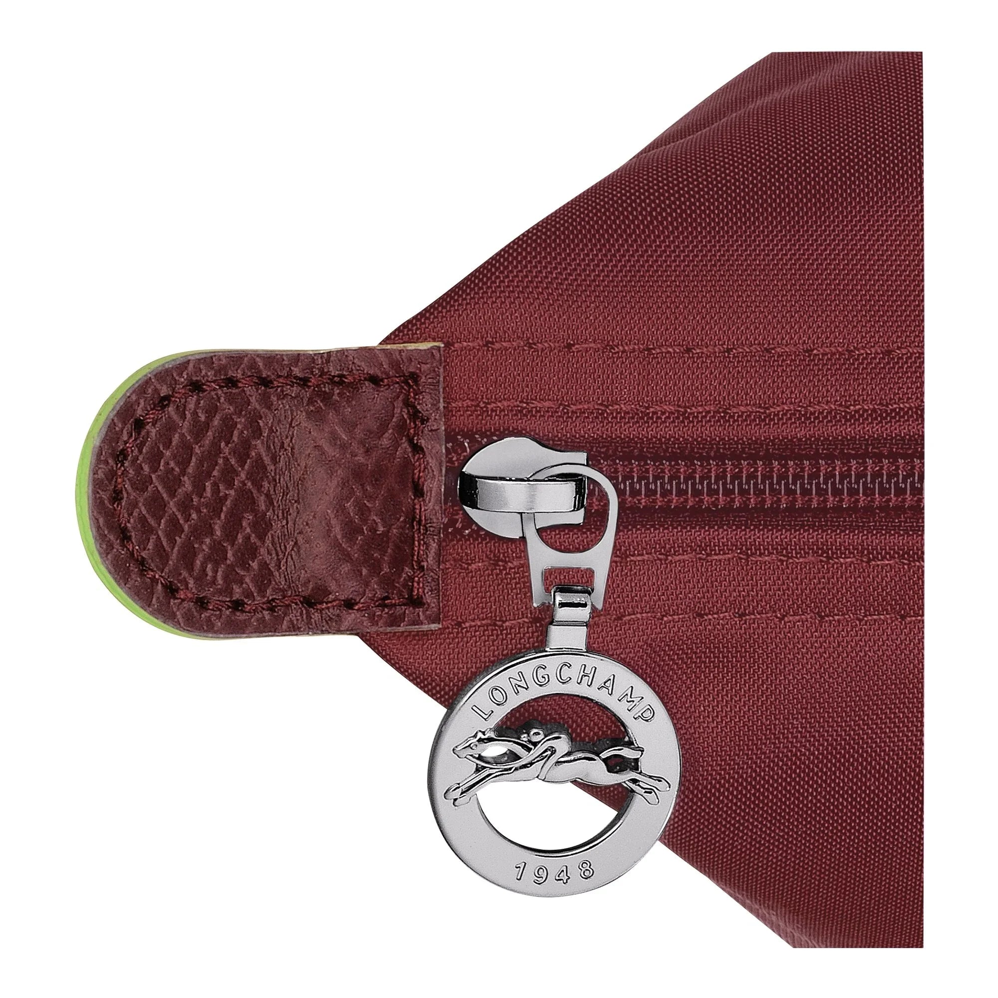 תקריב של רוכסן תיק בורדו עם תגית מתכת ממותגת LONGCHAMP, מותג מוביל מקבוצת אלפא