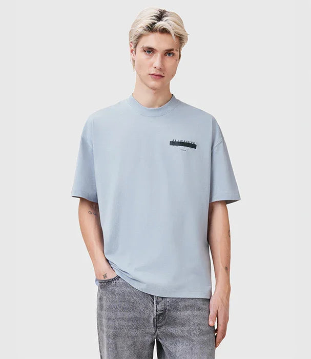 דוגמן לובש חולצת טי תכלת של ALLSAINTS ומכנסי ג'ינס אפורים, צילום לאתר CHOZEN