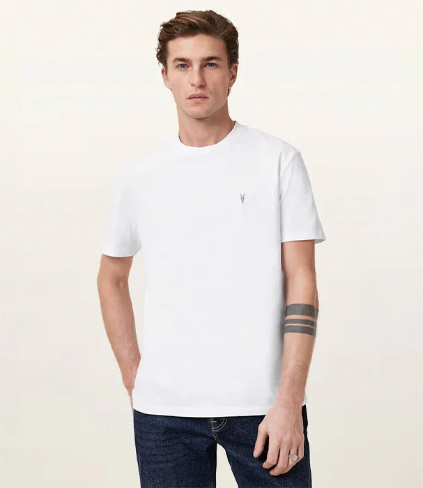 גבר לובש חולצת טי לבנה עם סמל קטן, ג׳ינס כהה, צילום אופנה למותגי יוקרה ב-CHOZEN