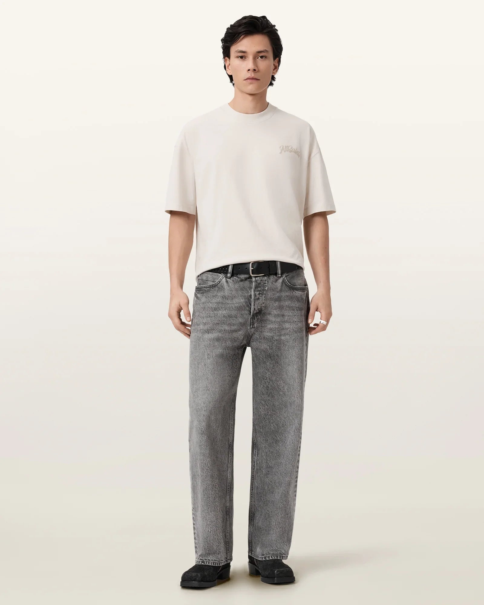 גבר לובש חולצה לבנה קצרה וג'ינס אפור רחב, ביגוד אופנתי לגבר