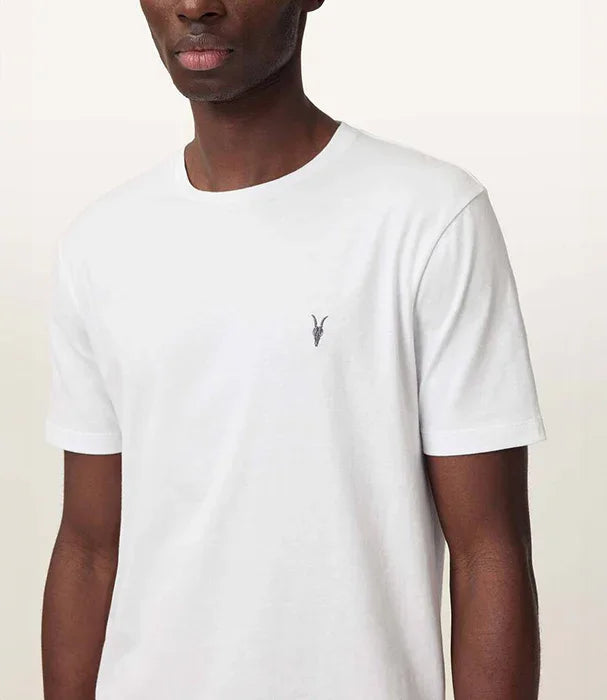 גבר לובש חולצת טי שירט לבנה עם לוגו קטן של מותג CHOZEN