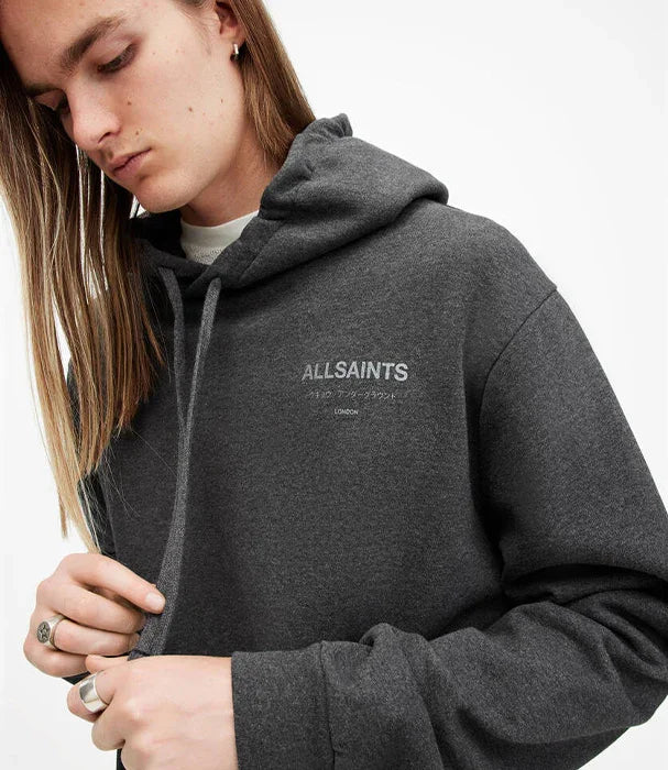 אדם לובש קפוצ׳ון אפור מבית המותג ALLSAINTS, אופנה מובילה מקבוצת אלפא ב-CHOZEN