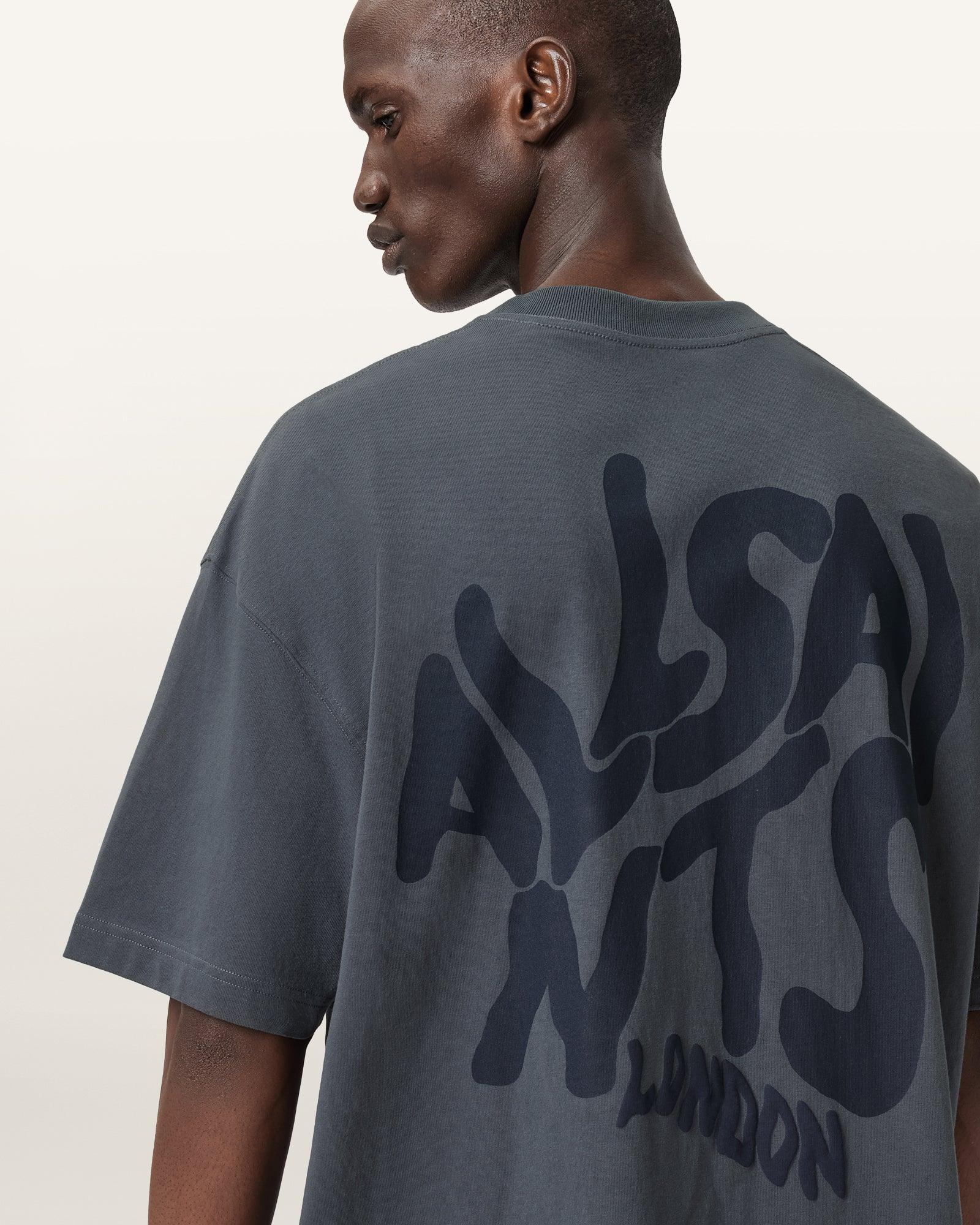 גבר לובש חולצת טי אפורה עם כיתוב ALLSAINTS LONDON, מותג אופנה מוביל ב-CHOZEN