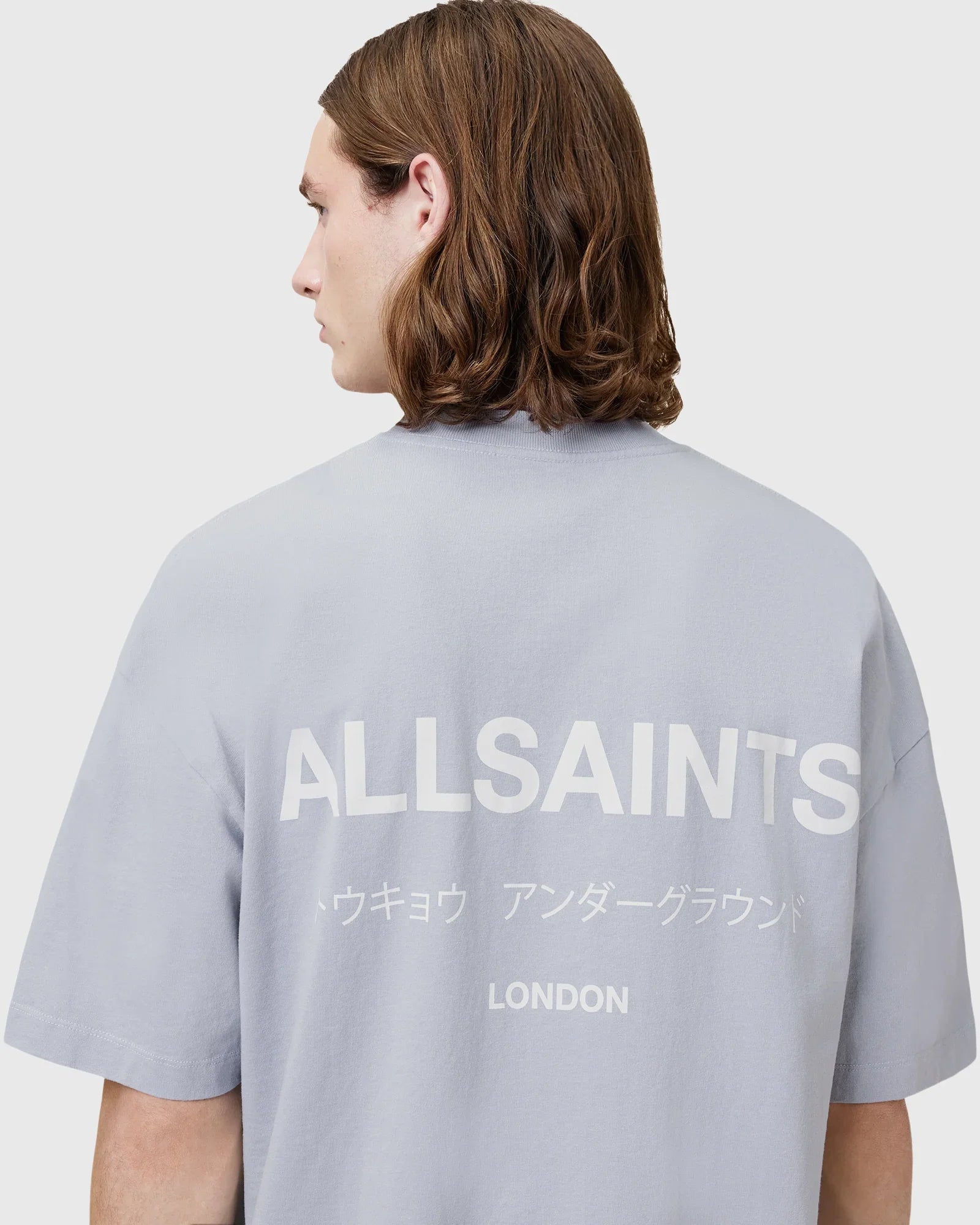 גבר לובש חולצת טי שירט אפורה עם לוגו ALLSAINTS, מיתוג אופנה יוקרתית מבית CHOZEN