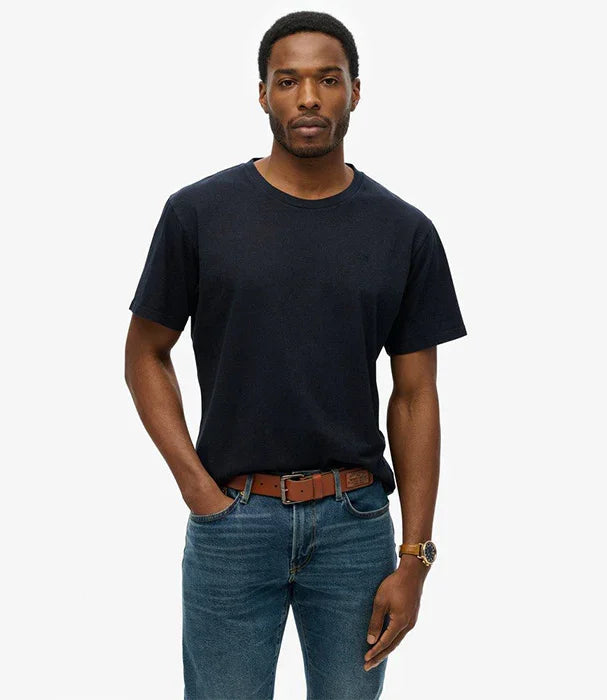 גבר עם חולצת טי שחורה, ג'ינס כחול וחגורת עור חומה מצולם על רקע לבן, אופנת CHOZEN