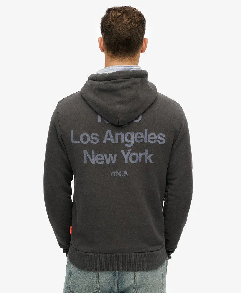 גבר עם סווטשירט כהה של CHOZEN, כיתוב Los Angeles New York בגב, קבוצת אלפא מותגים