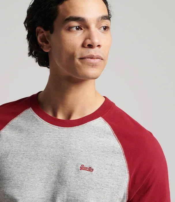 גבר לובש חולצת שרוולים אדומים-אפור עם לוגו Superdry, רקע נייטרלי, אופנה CHOZEN
