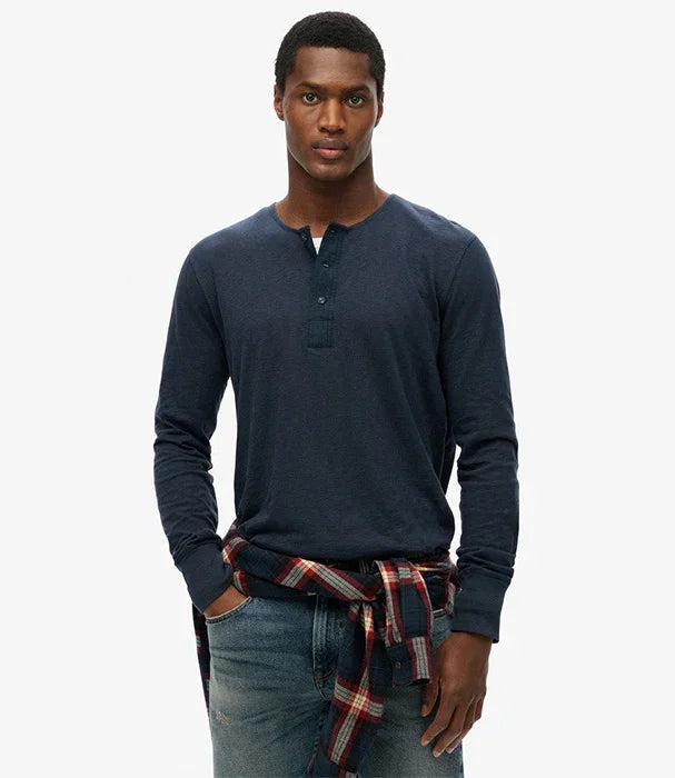 דגם גבר לובש חולצת הנלי כחולה עם שרוולים ארוכים, ג'ינס ופלנל קשור במותניים, אופנת CHOZEN