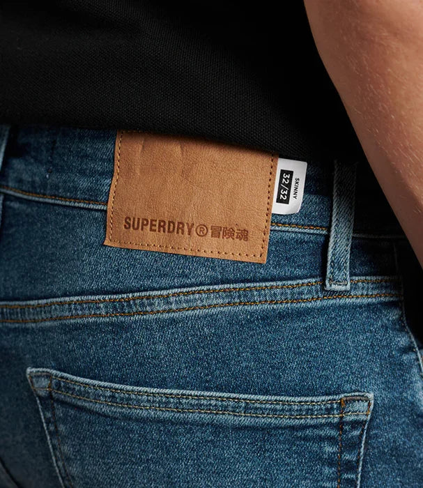 תג עור של SUPERDRY על ג'ינס כחול, צילום מקרוב, אופנה ב-CHOZEN