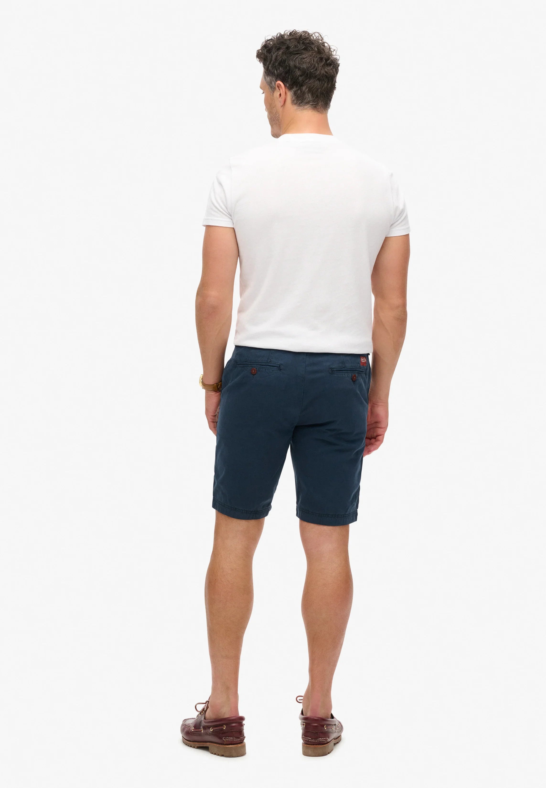 גבר לובש טי שירט לבנה ומכנסיים קצרים כחולים מבית CHOZEN, צילום מאחור, אופנת קיץ לגבר