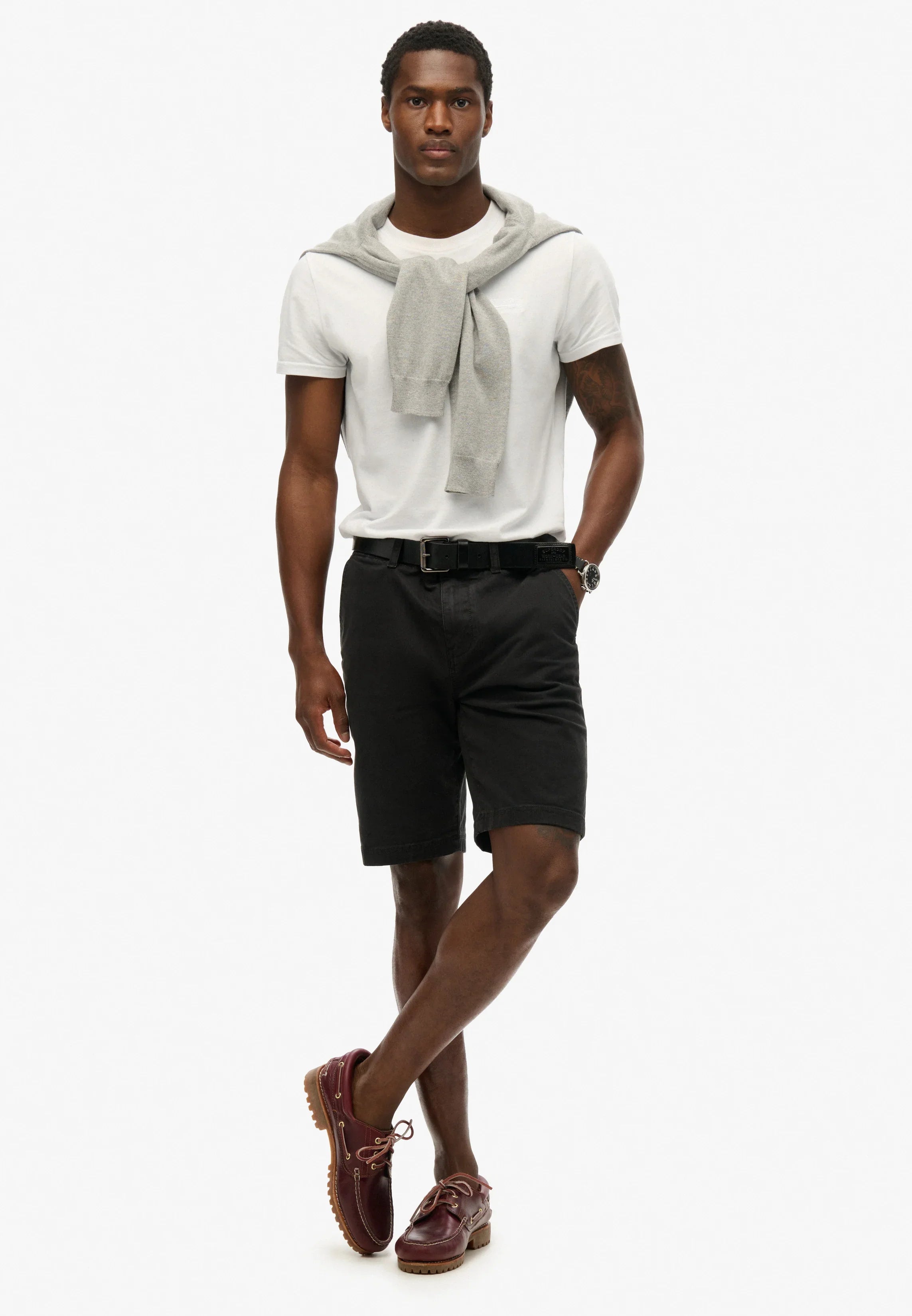 דגם לובש חולצת טי לבנה, סוודר אפור, מכנסיים קצרים שחורים ונעלי מוקסין חום, אופנת גברים CHOZEN