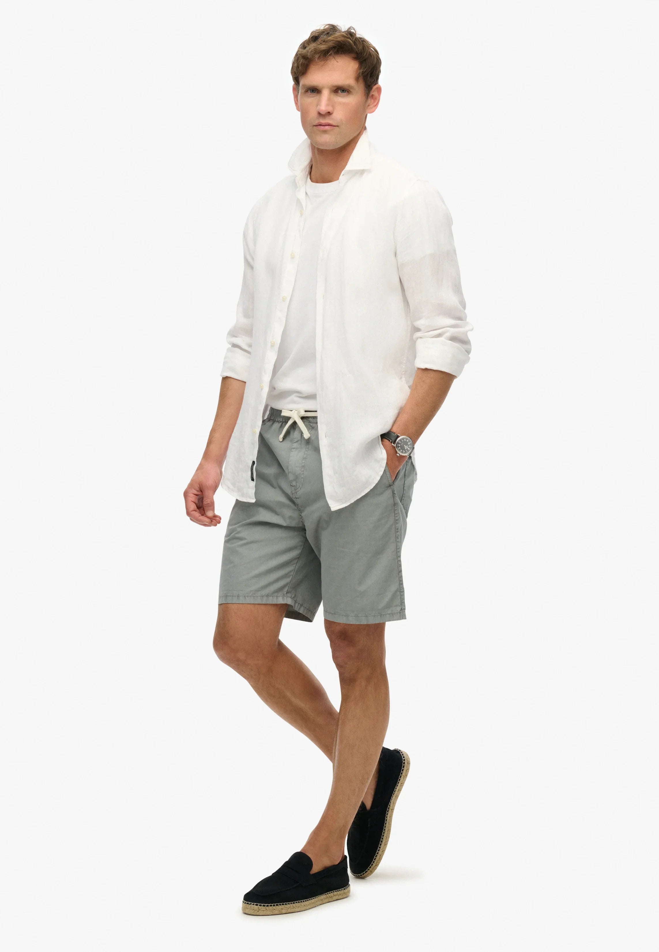 גבר במראה קיץ אופנתי ל-CHOZEN: חולצה לבנה קלה, מכנס קצר אפור ונעלי אספדריל שחורות