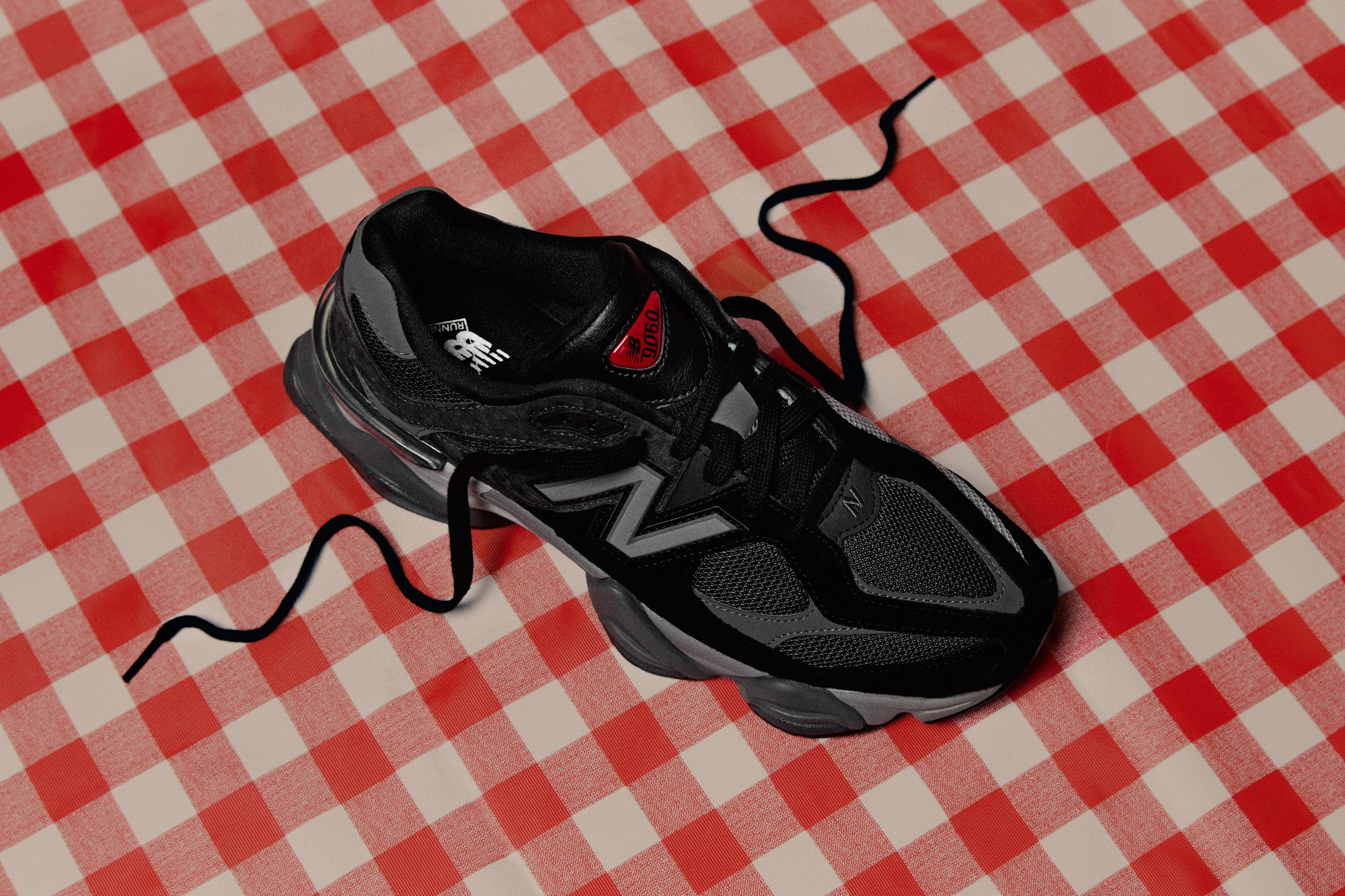 סניקרס ניו באלאנס שחורות דגם U9060BLK על מפה משובצת אדום-לבן, מאתר CHOZEN מותגי נעליים