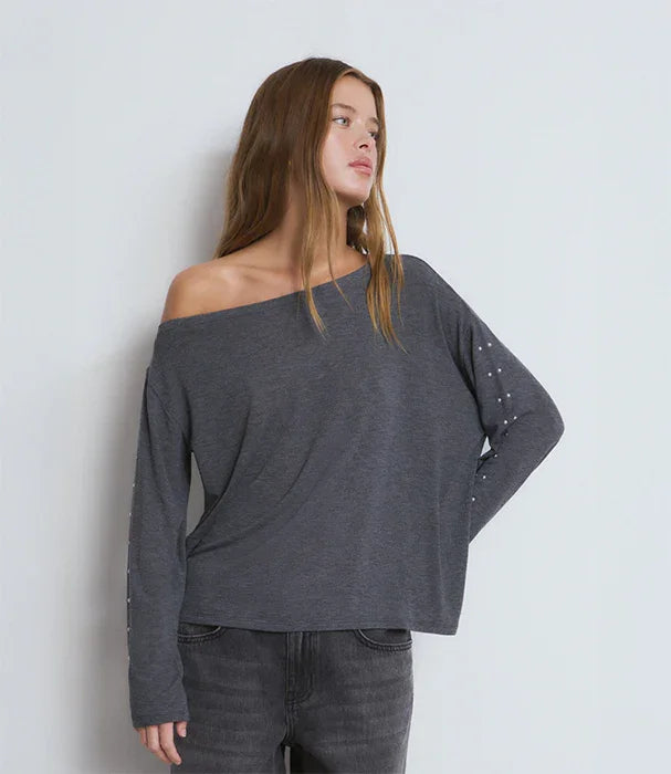 דוגמנית עם חולצה כהה בעלת מפתח כתף רחב, אופנה טרנדית CHOZEN, צילום בסטודיו