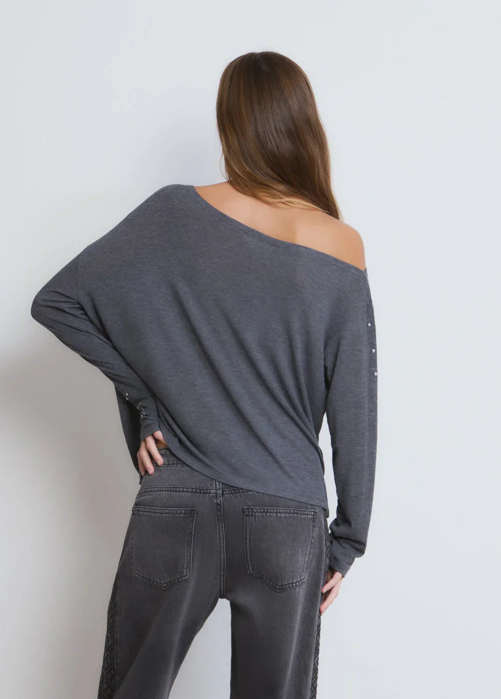 אישה עם חולצה אפורה ארוכה ומכנסי ג'ינס כהים, מבט מאחור, CHOZEN, אופנה טרנדית