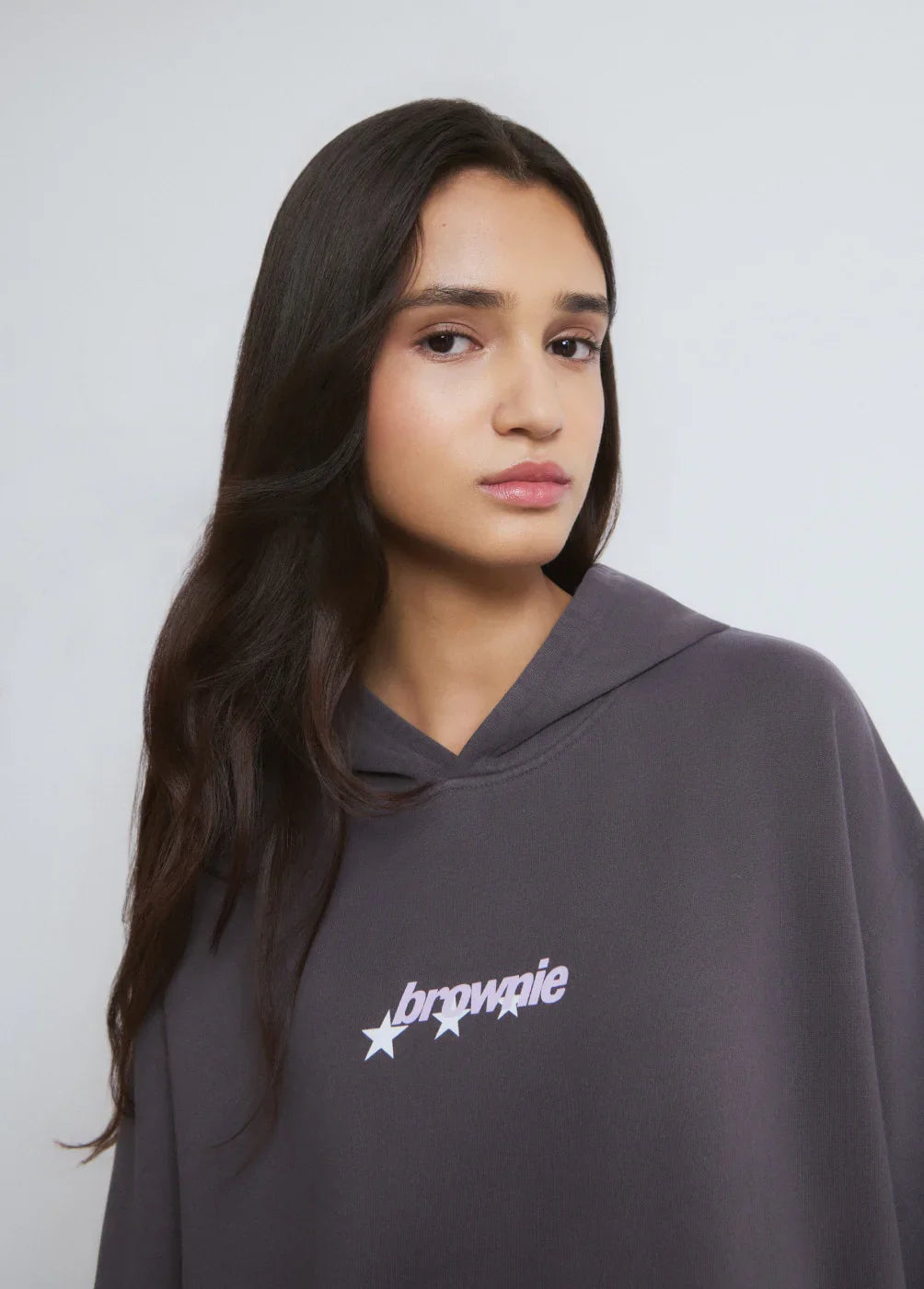 אישה לובשת קפוצ׳ון אפור עם כיתוב 'brownie' וכוכבים, קולקציית אופנה CHOZEN