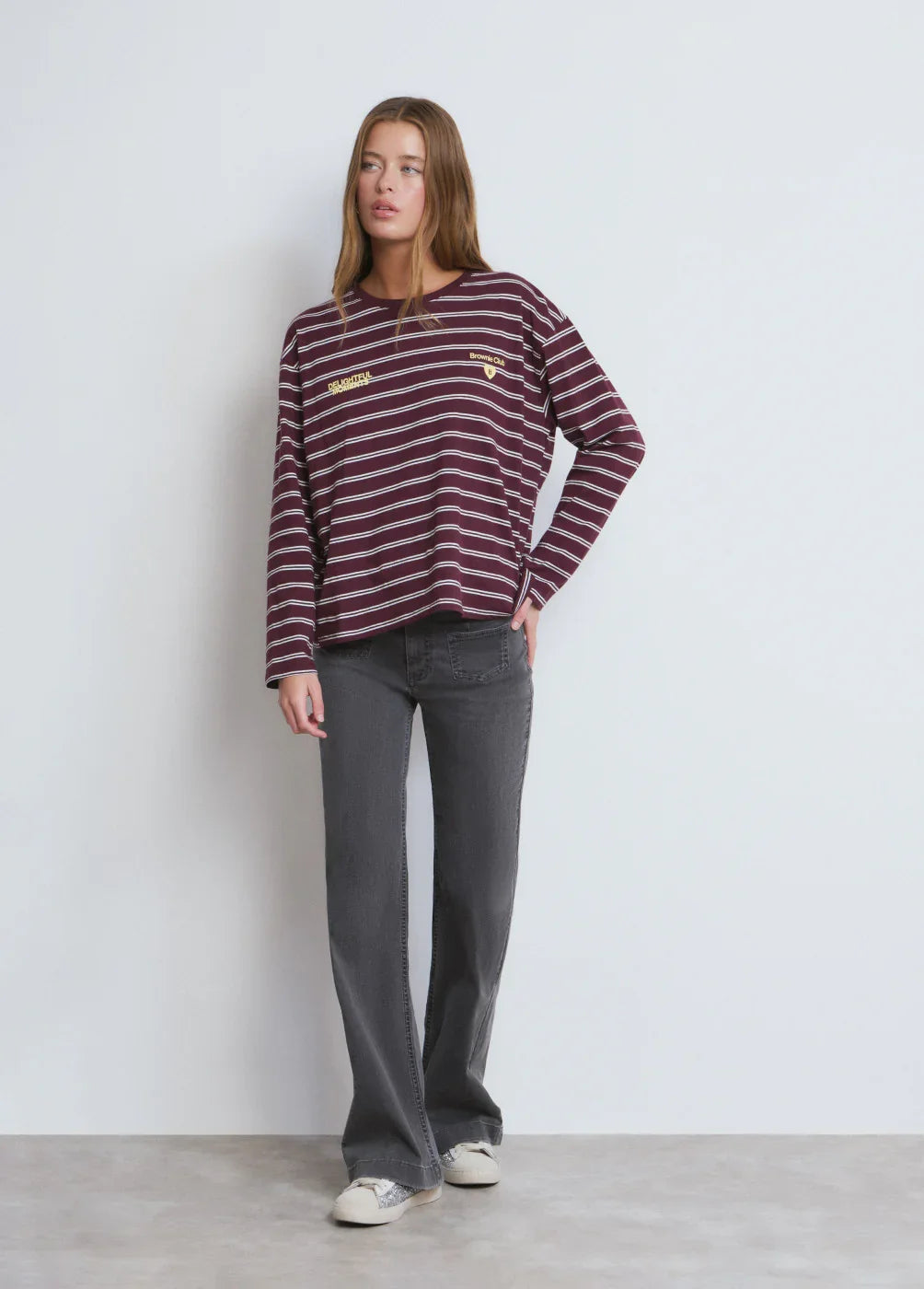 אישה לובשת חולצת פסים בורדו-לבן ומכנסי ג'ינס כהים, אופנה עדכנית מחנות CHOZEN