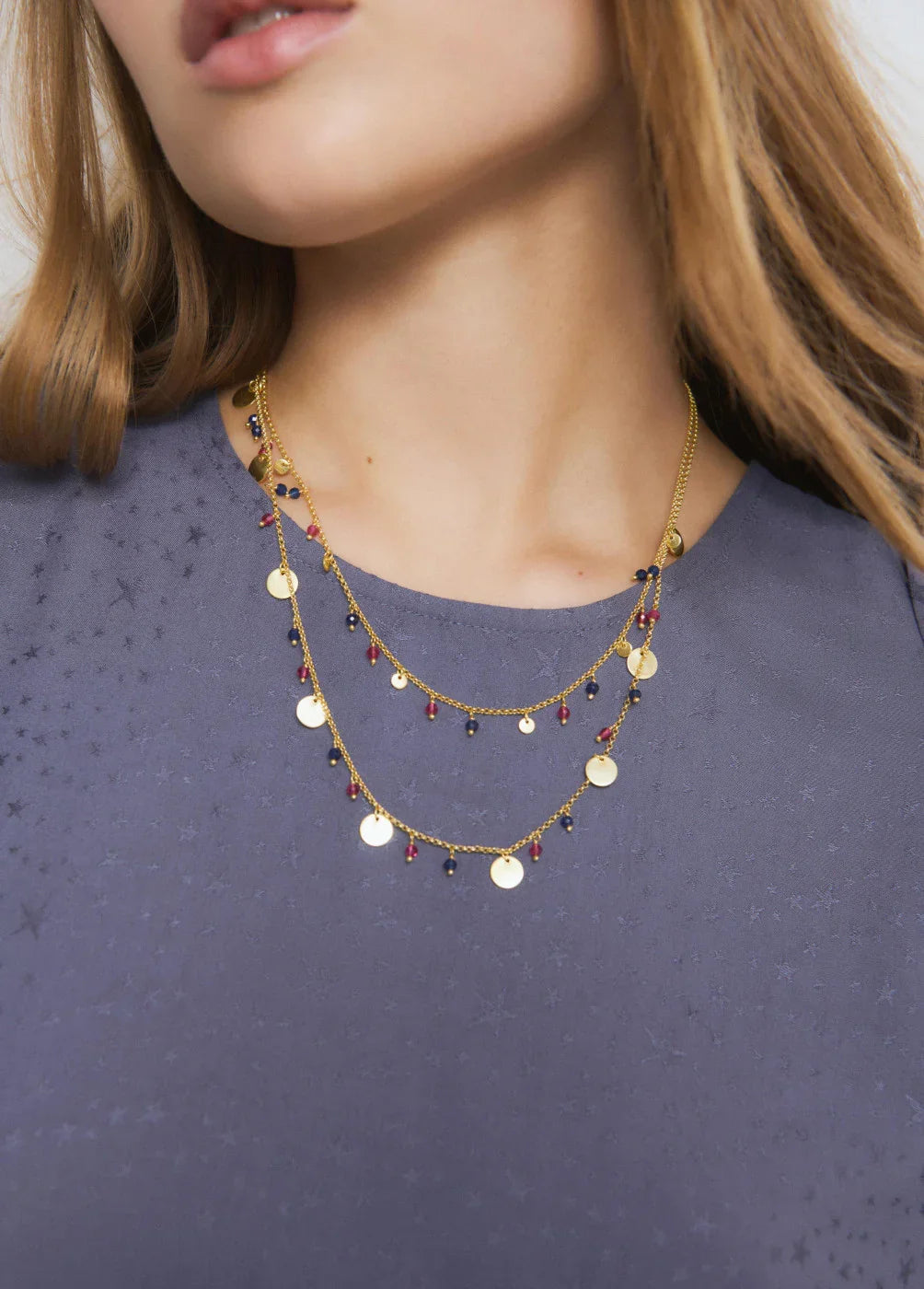 שרשרת זהב CHOZEN עם תליון עיגולים ואבני חן אדומות וכחולות על דוגמנית