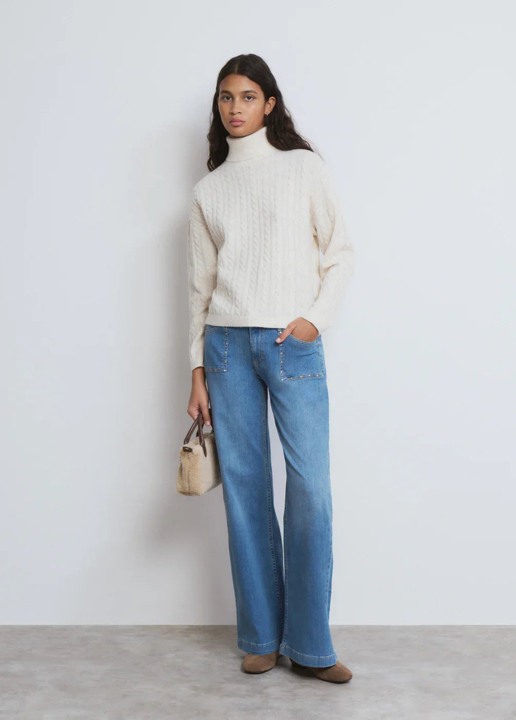 דוגמנית עם סוודר צמר לבן, ג'ינס רחב ותיק יד, אופנת נשים CHOZEN קבוצת אלפא