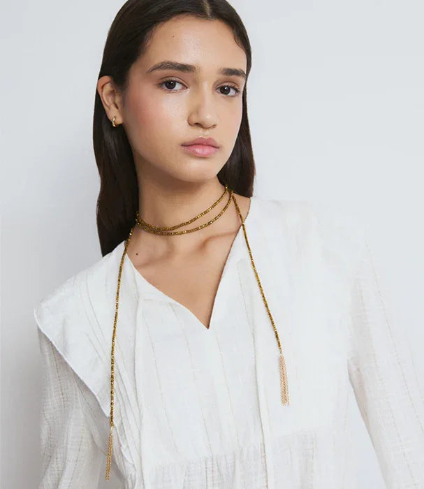 אישה עם שמלה לבנה ושרשרת זהב אלגנטית, צילום אופנה באתר CHOZEN