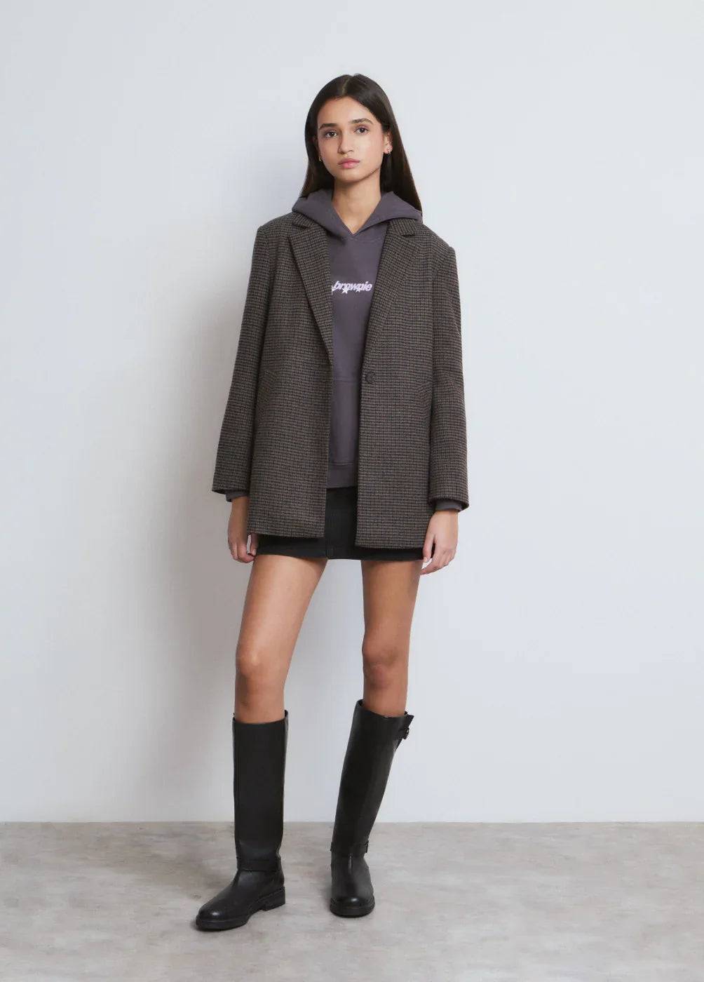 אופנת נשים CHOZEN: דוגמנית עם בלייזר משובץ, סווטשירט כהה, חצאית שחורה ומגפיים גבוהים