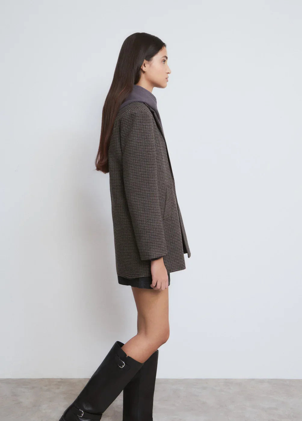 אופנת נשים עדכנית של CHOZEN, דוגמנית עם ז'קט משובץ, מגפיים שחורים ובגדים אלגנטיים