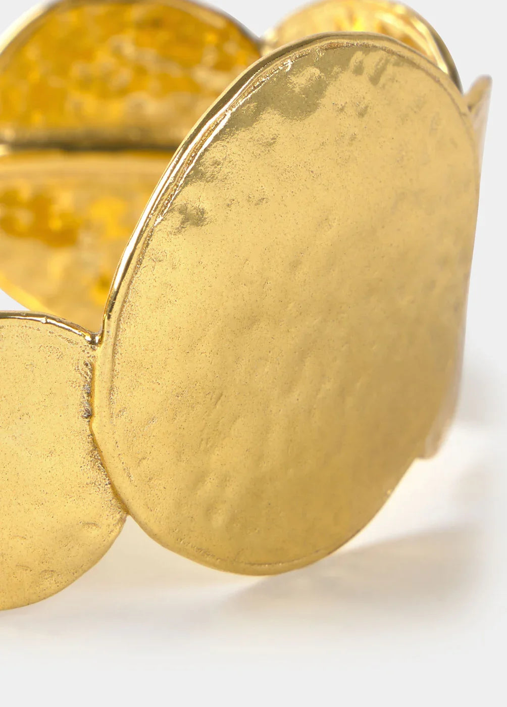 תclose-up of textured gold metal bracelet with עיצוב גיאומטרי ייחודי