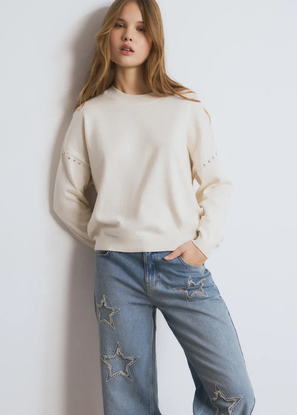 דוגמנית לובשת סווטשירט שמנת וג'ינס עם כוכבים, אופנה עדכנית מבית CHOZEN