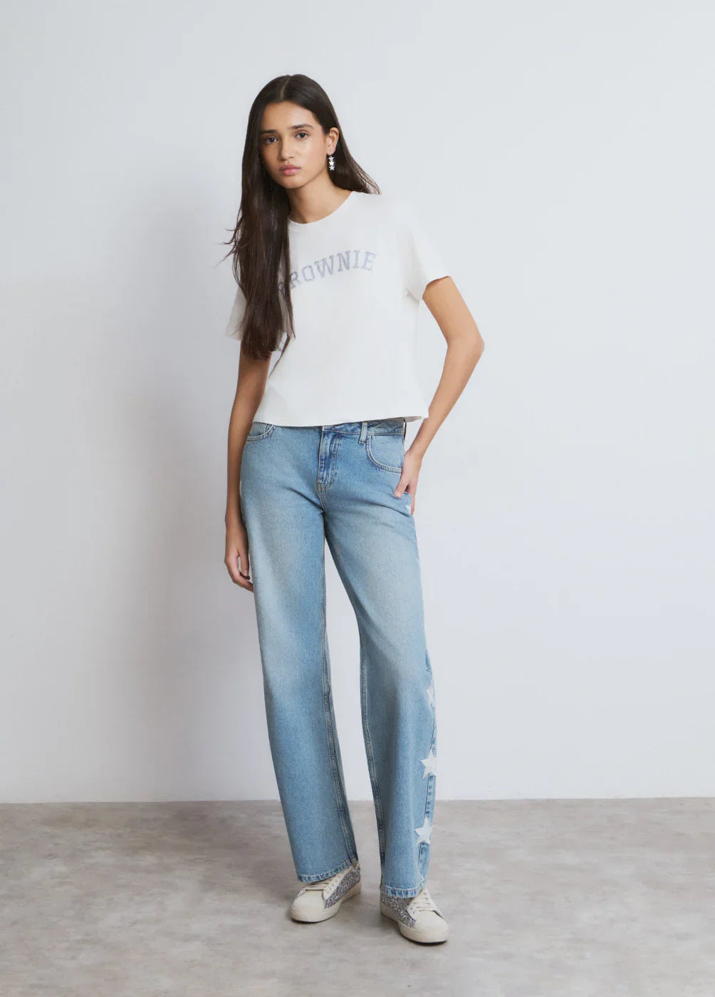 דוגמנית לובשת ג'ינס כחול רחב עם כוכבים ולוק קז'ואל של CHOZEN, קבוצת אלפא