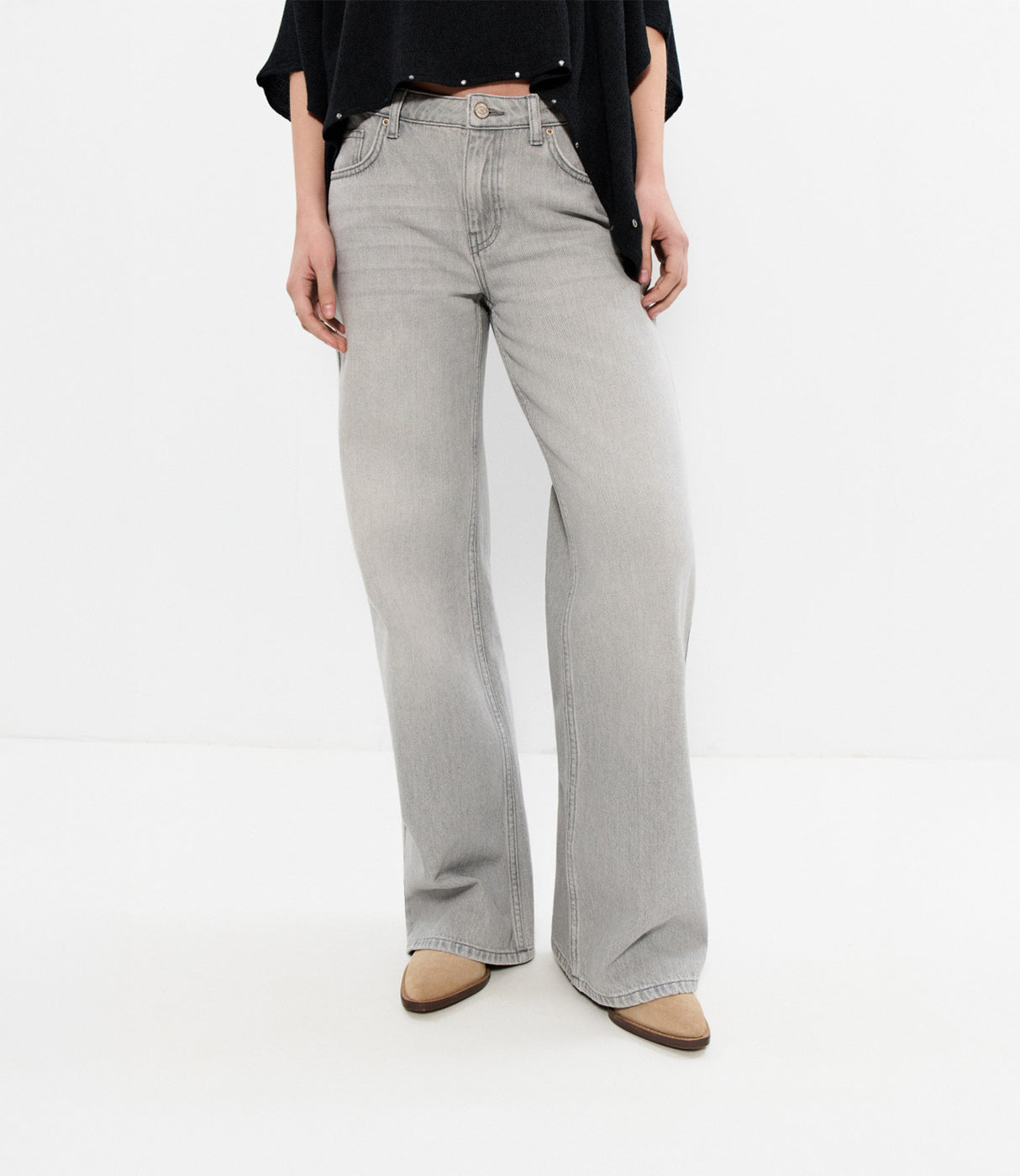 מכנסי ג'ינס רחבים לנשים בגוון אפור, סגנון קז'ואל, על רקע לבן