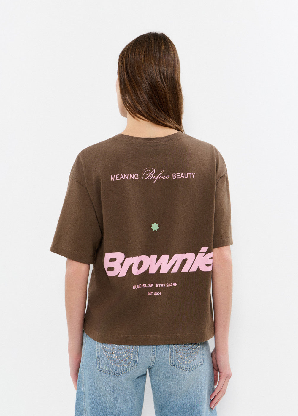 חולצת טישרט חומה עם הדפס ורוד בגב, כיתוב 'Brownie', לבושה על אישה עם שיער ארוך