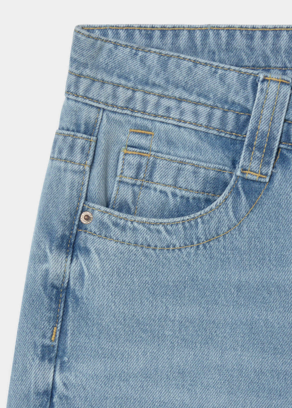 גזור תקריב של ג'ינס דנים כחול עם תפרים בצבע צהוב וכיס קדמי