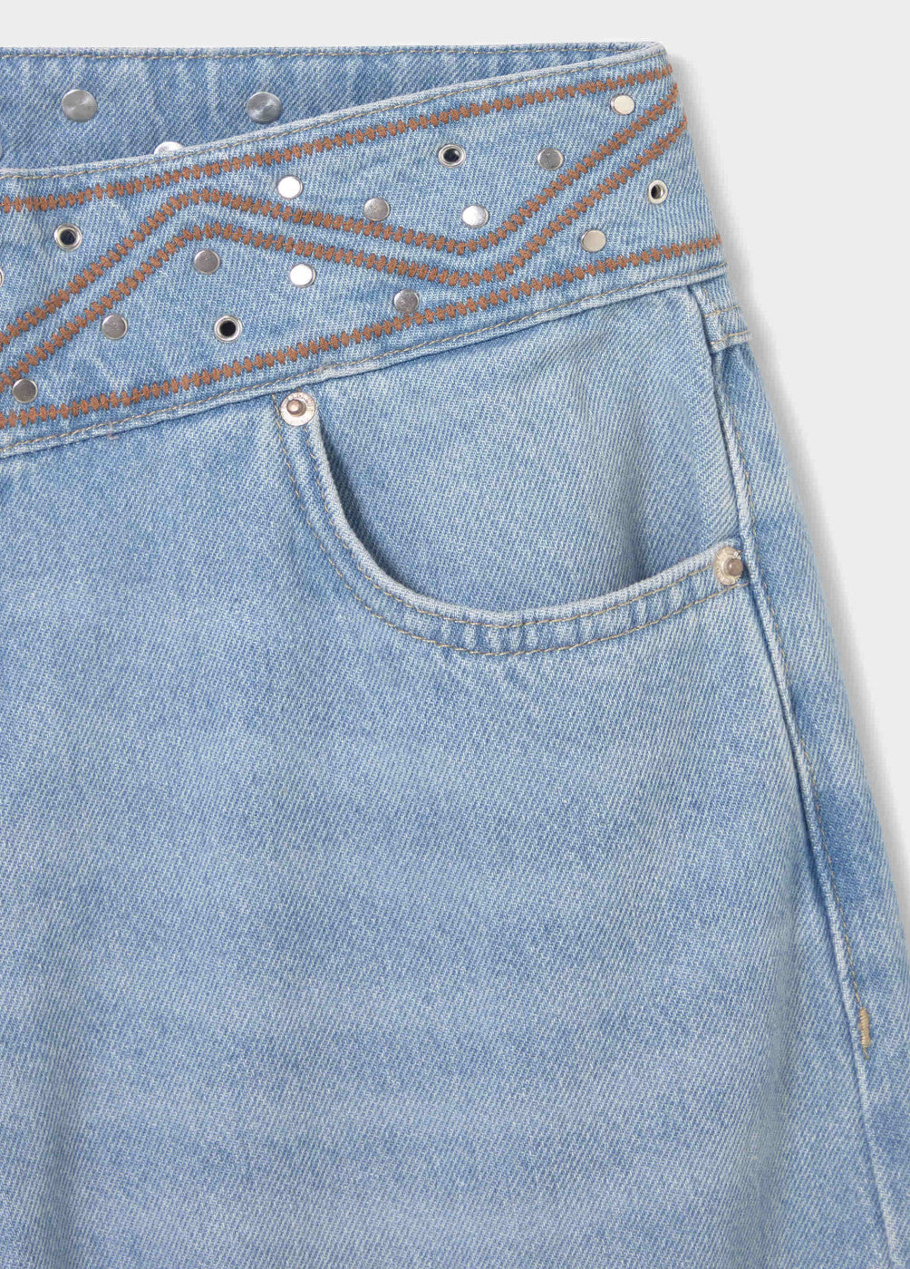 ג׳ינס בהיר עם כיס קדמי, עיטורי ניטים ותפר חום באזור המותן