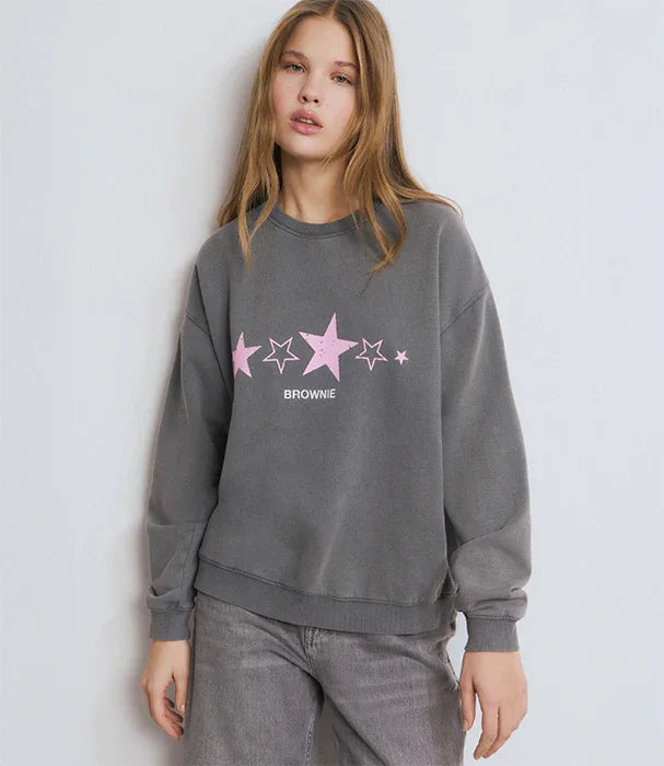 דוגמנית לובשת סווטשירט אפור עם כוכבים ורודים וכיתוב BROWNIE, אופנה לנשים CHOZEN
