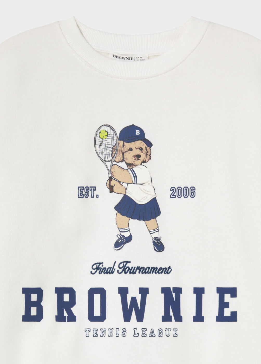 סווטשירט לבן עם ציור של כלב שמשחק טניס, חובש כובע כחול ולובש חצאית כחולה