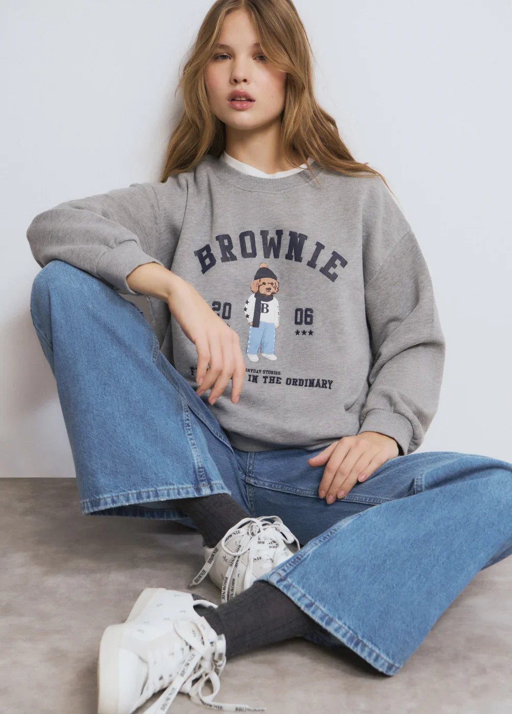 צעירה עם סווטשירט אפור עם הדפס Brownie, ג'ינס רחב ונעלי ספורט לבנות, אופנת CHOZEN