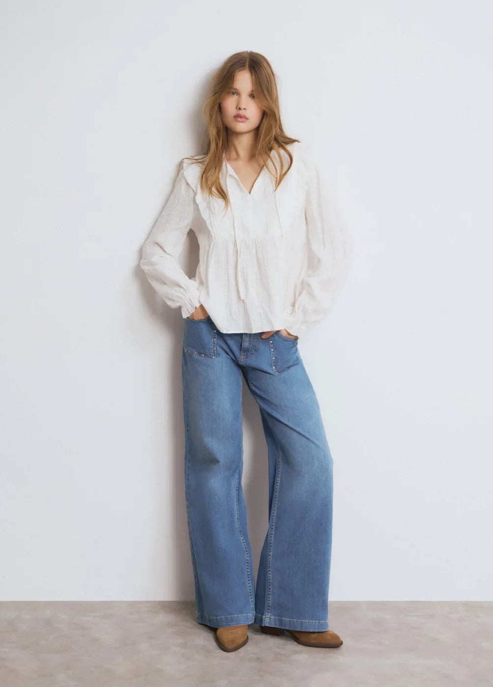 דוגמנית עם חולצה לבנה מכופתרת ומכנסי ג׳ינס רחבים, אופנה עדכנית באתר CHOZEN