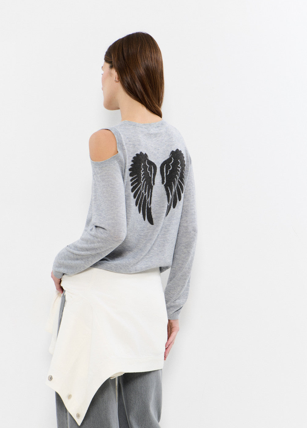 אישה עם סווטשירט אפור עם הדפס כנפיים בגב וכתפיים חשופות, בגדי אופנה נוחים