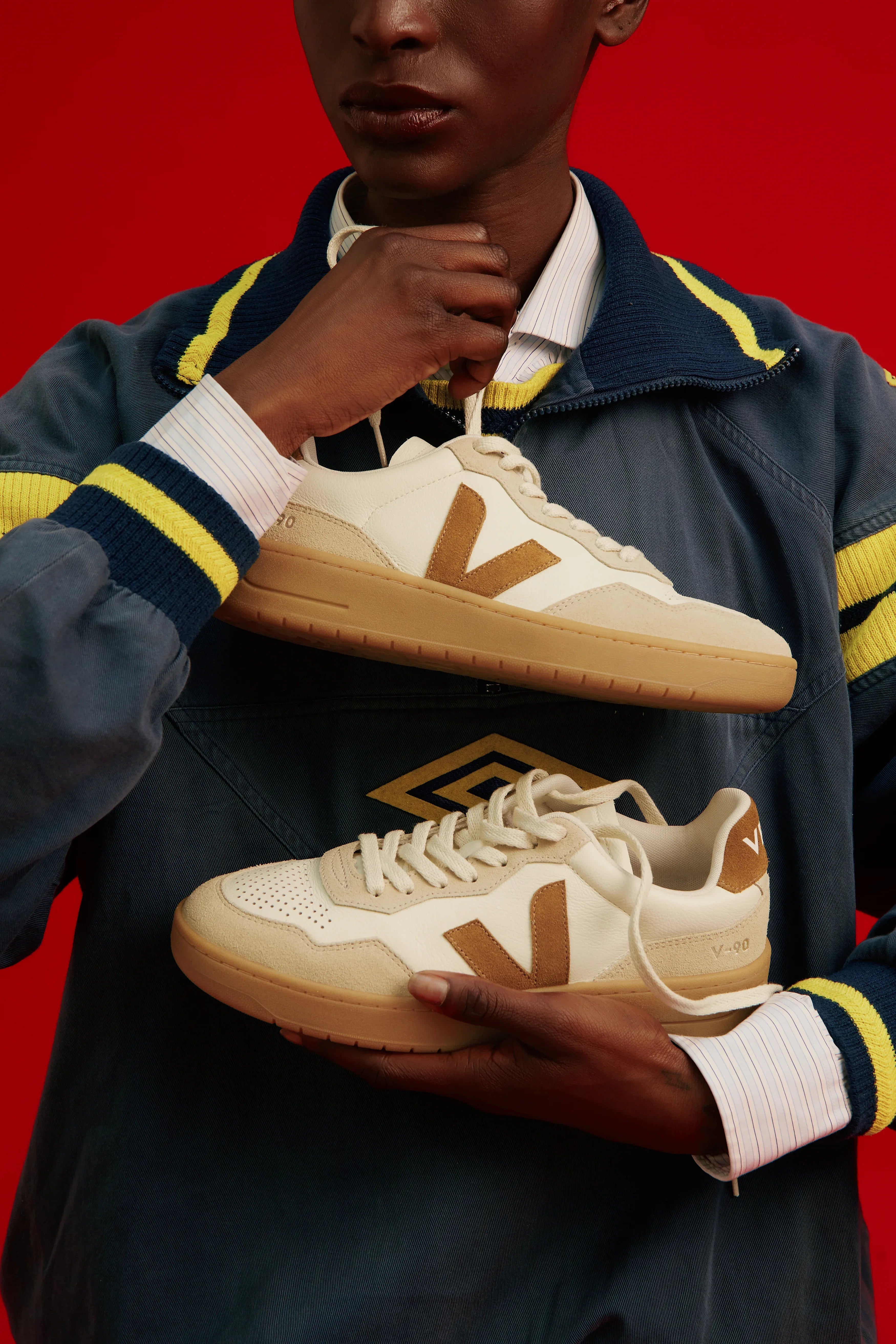 דגם סניקרס Veja V-90 בצבע בז‘ ולבן, מוצג על רקע אדום, HOMEPAGE CHOZEN קבוצת אלפא