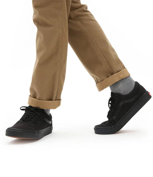 נעלי ואנס שחורות קלאסיות על רקע לבן, נלבשות עם מכנסי חאקי, מותג על מבית CHOZEN