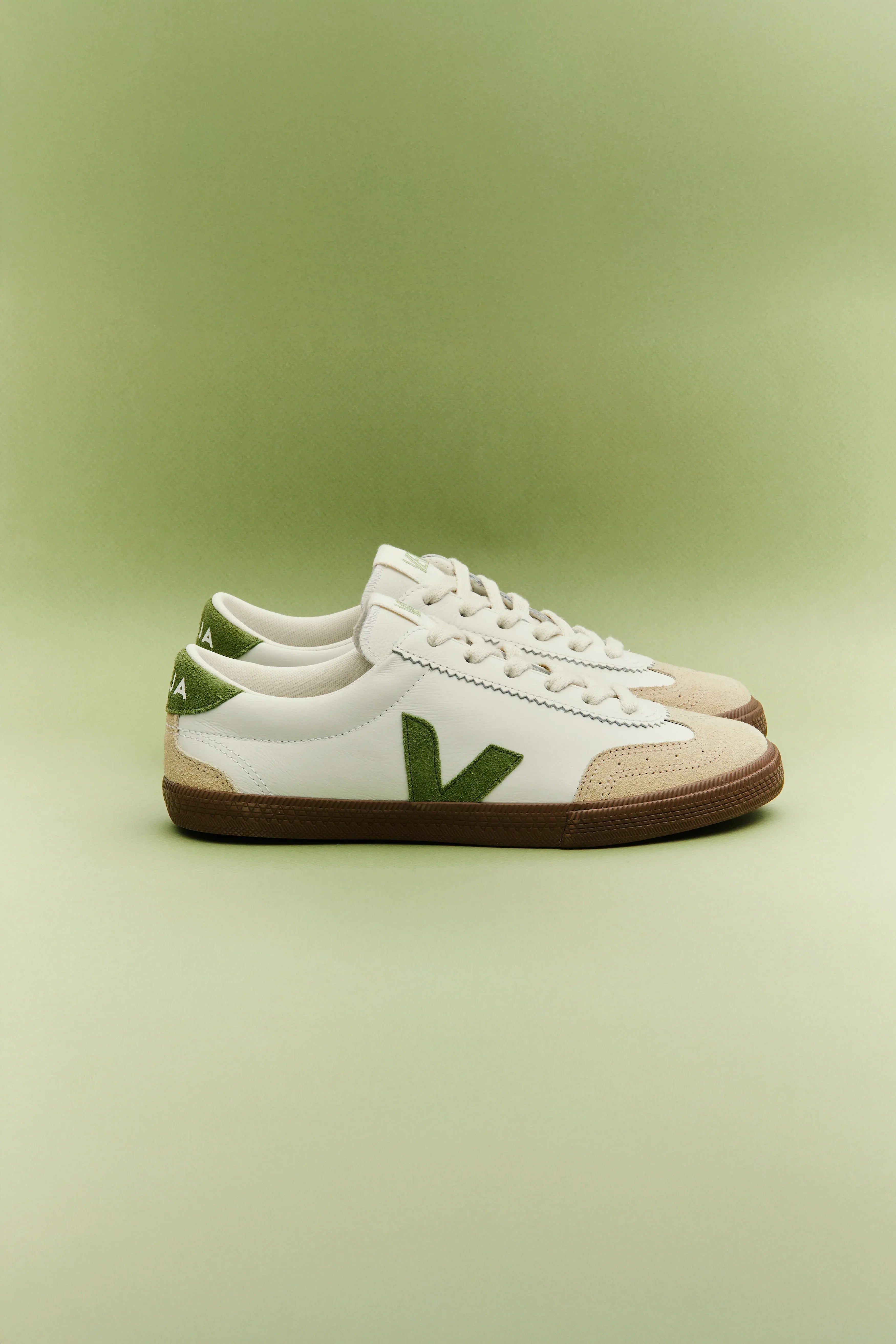נעלי סניקרס Veja לבנות עם סוליה חומה וסמל ירוק, צילום סטודיו רקע ירוק, מותגי CHOZEN