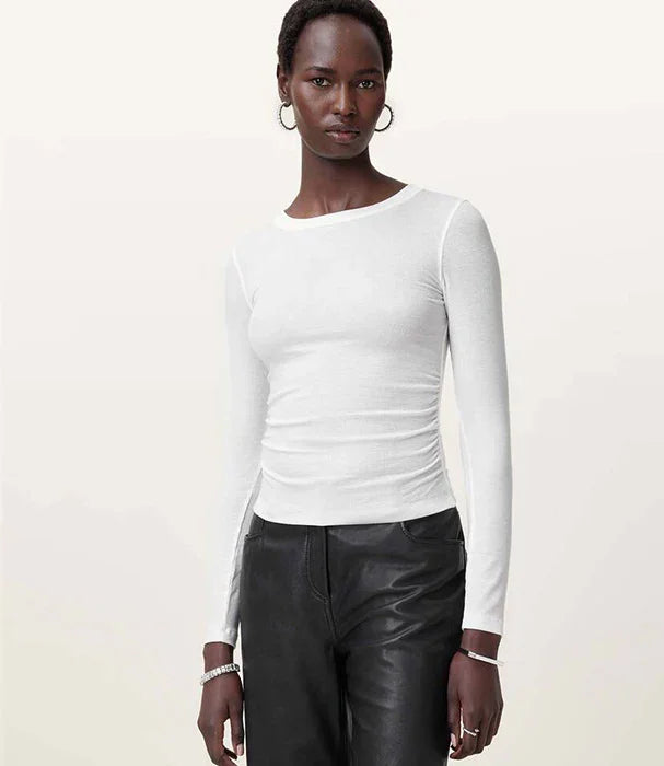 אישה עם חולצה לבנה ארוכה ומכנסי עור שחורים, צילום אופנה לאתר CHOZEN מותגים מובילים