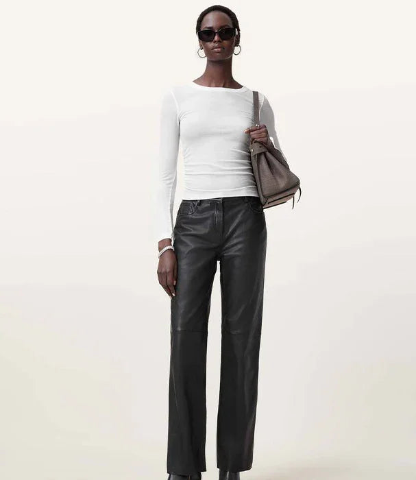 אישה עם חולצה לבנה, מכנסי עור שחורים, תיק יוקרתי ומשקפי שמש, אופנה מבית CHOZEN