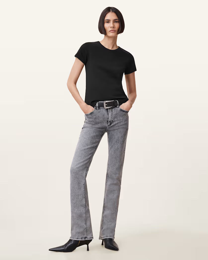 אישה לובשת ג׳ינס אפור בגזרה ישרה עם חולצה שחורה ונעלי עקב שחורות, אופנה לנשים