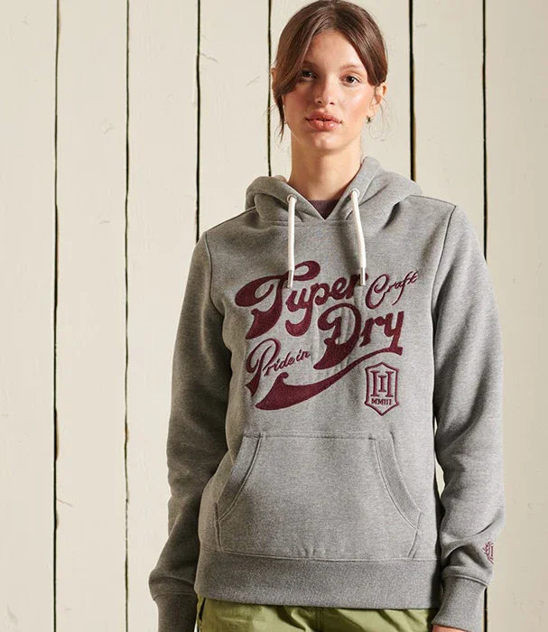 אישה לובשת קפוצ׳ון אפור עם כיתוב Superdry, אופנת חורף CHOZEN
