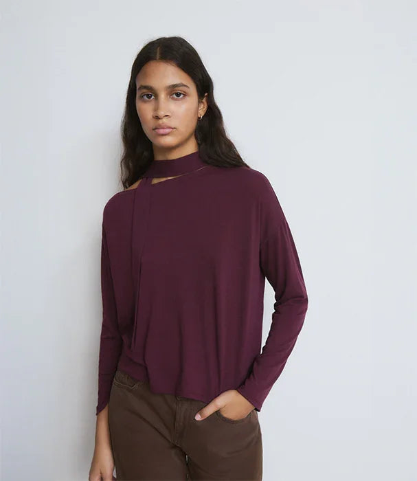 דוגמנית לובשת חולצה סגולה עם שרוולים ארוכים ועיצוב צוואר ייחודי, צילום לאתר CHOZEN