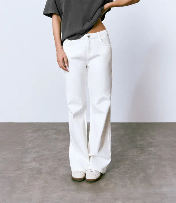 דוגמנית לובשת מכנסיים לבנים רחבים של CHOZEN על רקע נייטרלי, אופנה מבית קבוצת אלפא