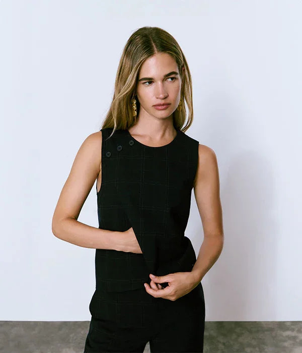 אישה עם שיער בלונדיני לובשת גופיית נשים שחורה אלגנטית, צילום אופנה ל-CHOZEN