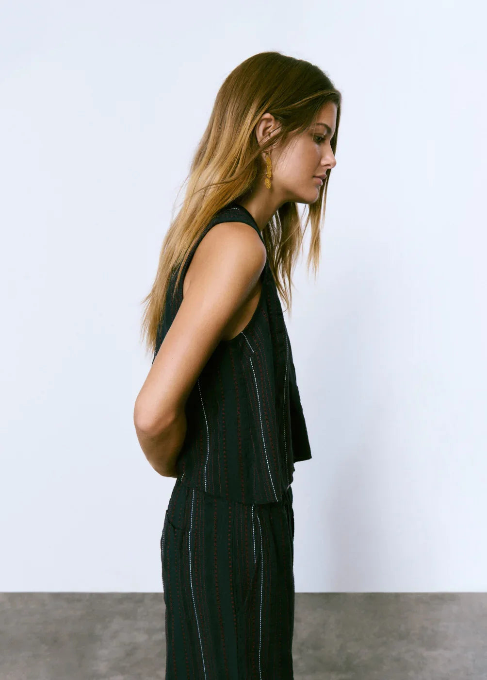 דוגמנית עם שיער בלונדיני לובשת חליפת נשים שחורה אופנתית מבית CHOZEN