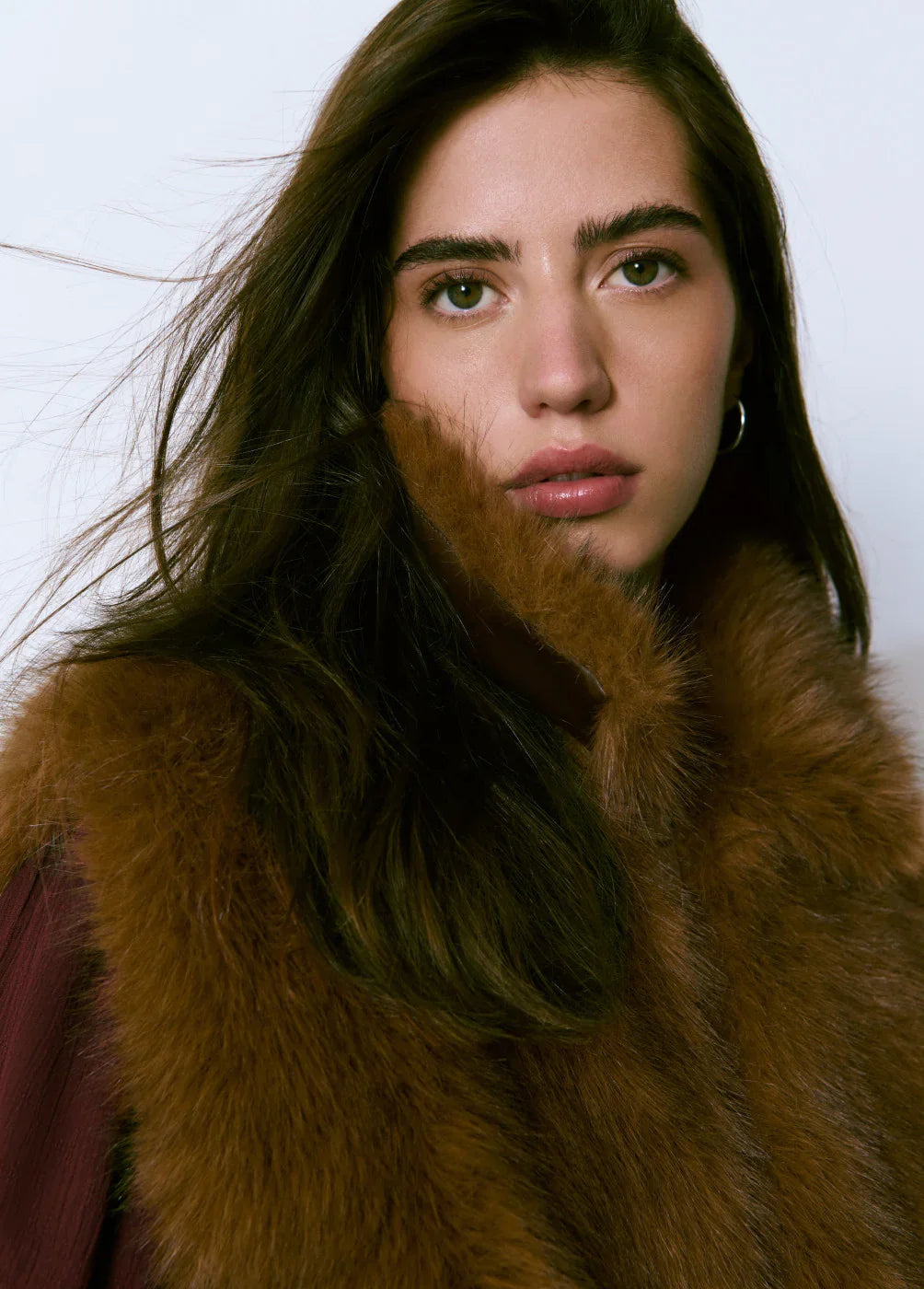 אישה צעירה לובשת מעיל פרווה חום, צילום אופנה יוקרתי ל-CHOZEN, מותגים מובילים